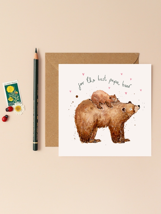 An endearing illustration of a father bear carrying its playful cub on its back, both exuding warmth and affection. The handwritten message "For the Best Papa Bear" is displayed above them, adding a personal touch. The design combines earthy tones and soft textures, capturing the bond between father and child.