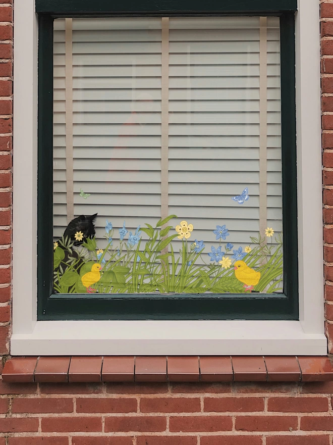 cat peering out of window with spring flowers window cling