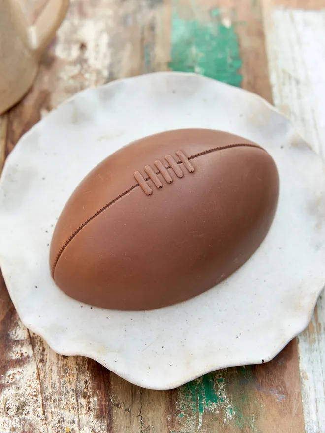 Giant half rugby ball on a speckled plate 