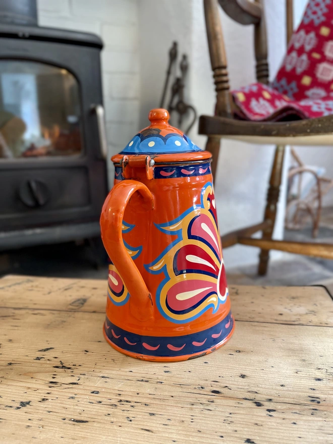 Orange vintage coffee pot, hand painted with a fairground inspired design in pink, red, orange, yellow and blue.