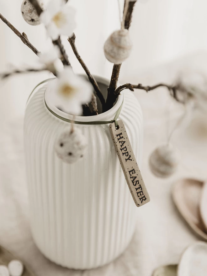 'Happy Easter' ceramic tag, tied around a white vase