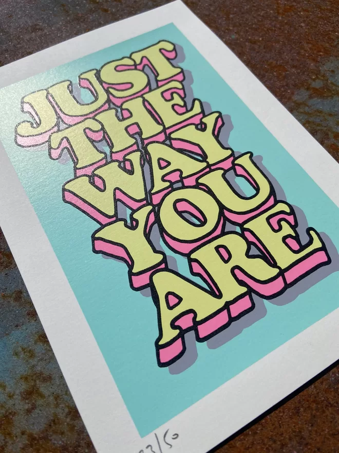 "Just The Way You Are” Mini A5 Hand Pulled Screen Print In pastel blue with the words just the way you are in hand drawn lettering printed on top with black outline and pink and yellow fill