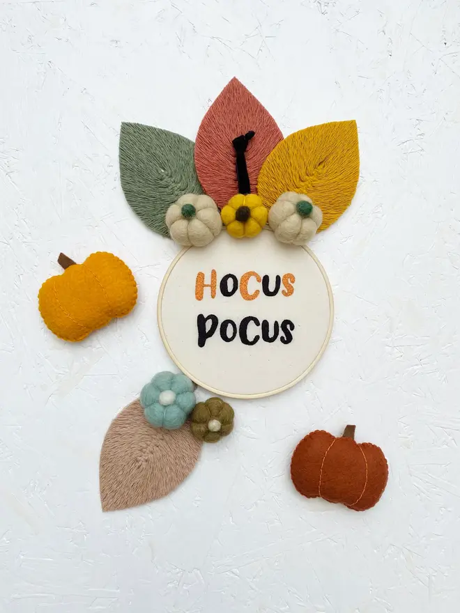 spooky phrase embroidered hoop. embroidered halloween hoops photographed with decorations.