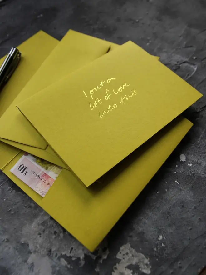 Hand foiled cash card or money wallet in a chartreuse green colour handfoiled in shiny yellow foil text which says ‘I put a lot of love into this’.