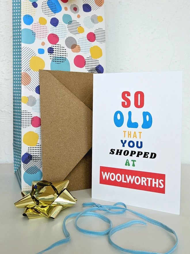A photograph of the front of a humorous A6 greeting card illustrated using brightly coloured text and the retro shop logo. The text says so old you shopped at Woolworths.