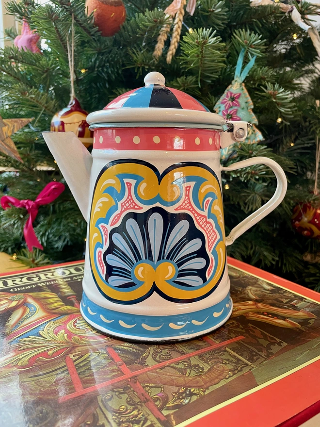 White enamel coffee pot hand painted with a fairground design in blue, pink and yellow