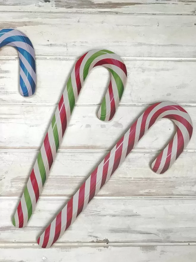 Candy Canes in two colours on a wooden floor.