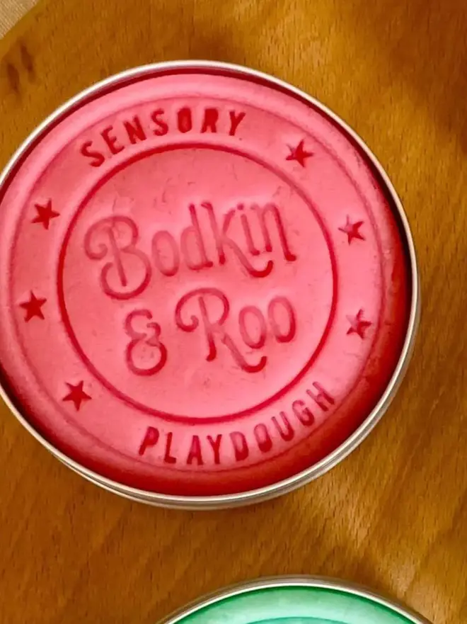 fairy sensory play dough sensory set. a tub of pink play dough.