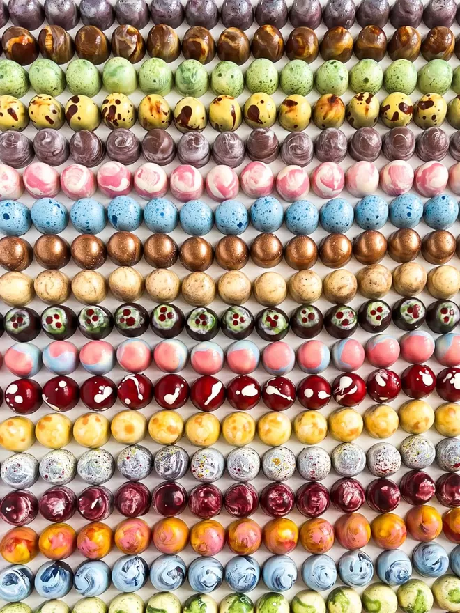 a collection of colourful chocolates on a white background