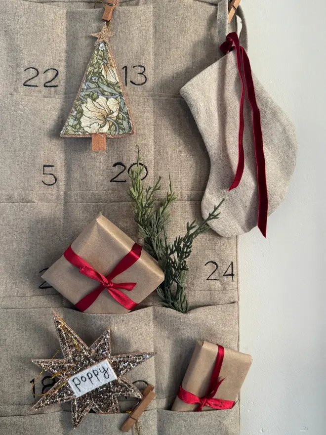 Linen Advent Calendar, close up of an embroidered linen advent calendar with small gifts in the pockets