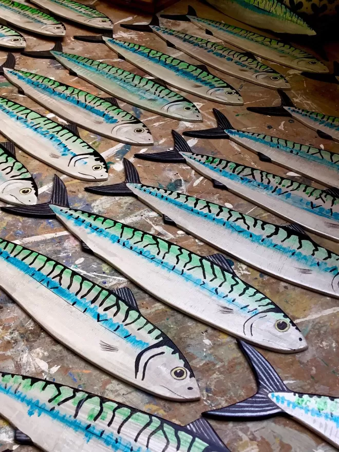 multiple mackerels laying on work surface freshly painted