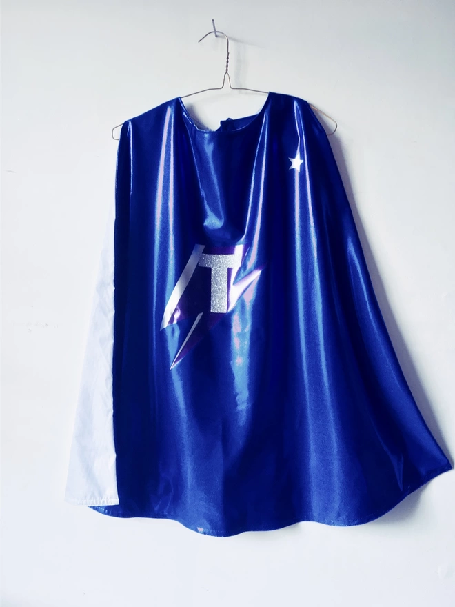 Blue Sapphire Superhero cape with silver grey lining, bowie lightning bolt design and a silver glitter 'T' initial.