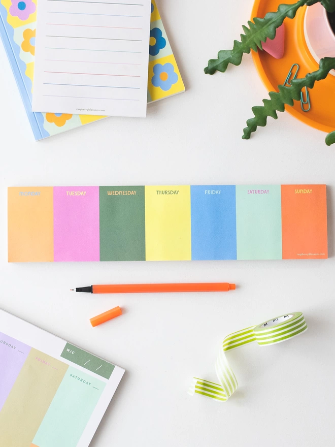 Raspberry Blossom Rainbow coloured keyboard jot pad sits on desk with other colourful stationery items from the Happiness Stationery collection