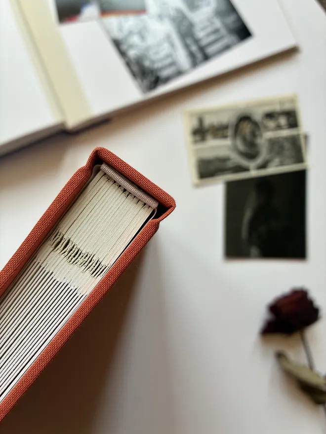 Close up of a hand made photograph album spine showing cloth jointed pages and headband detail