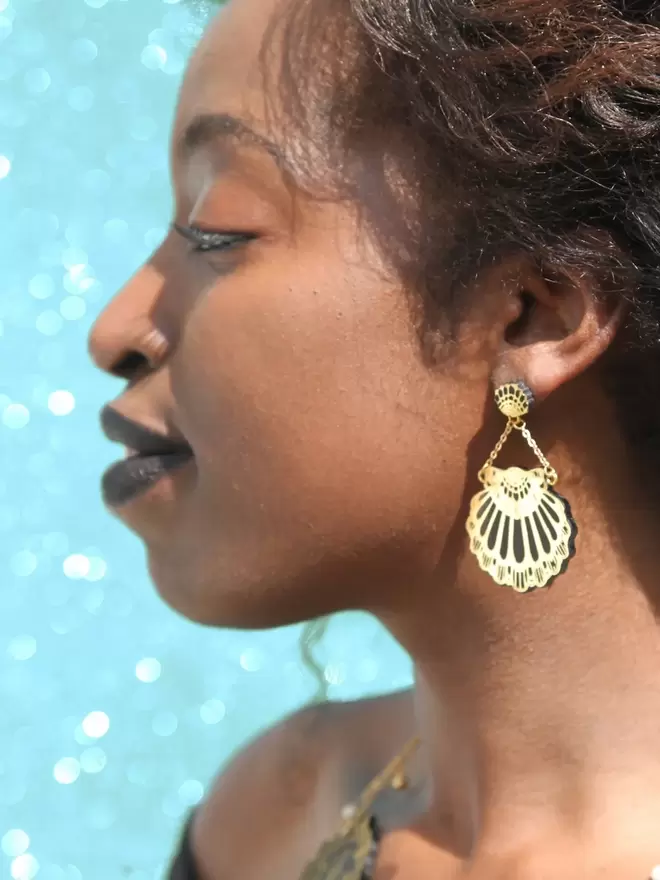 black & gold leather clamshell earrings on model