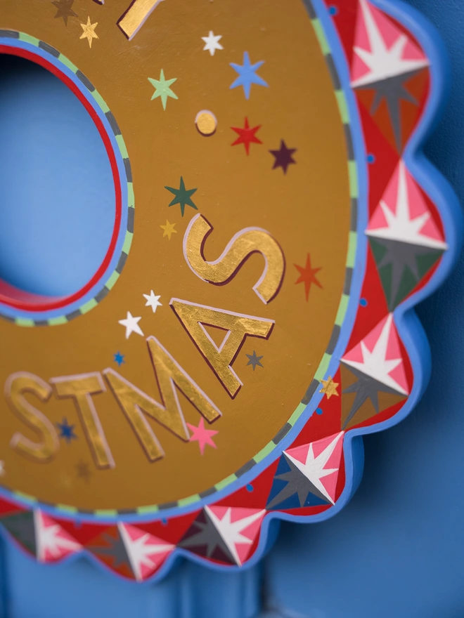 Multicoloured Hand painted Christmas Wreath with gold leaf lettering on a blue front door