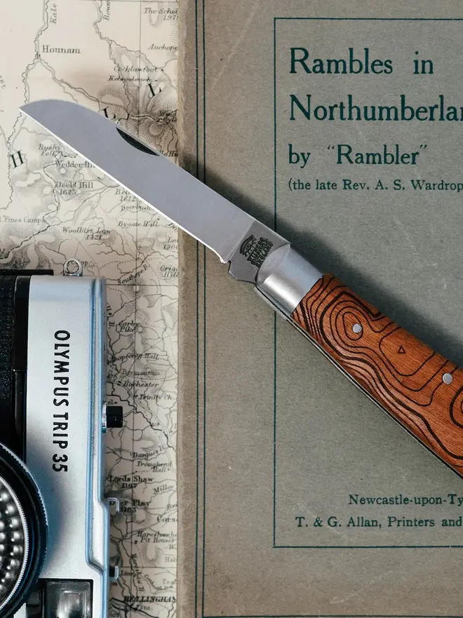 'the cheviot' folding pocket knife. a steel pocket knife with a brown wooden handle.
