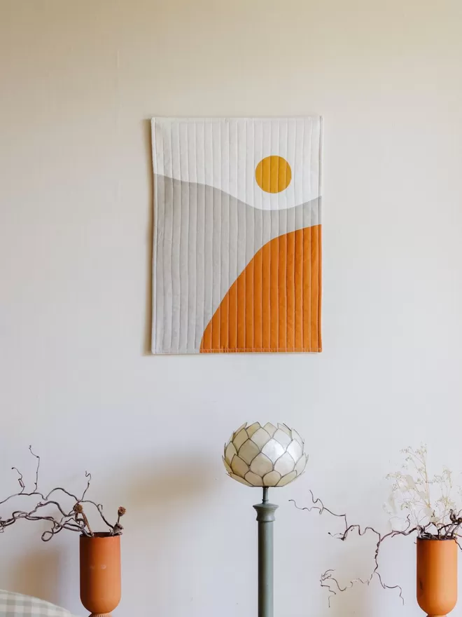 Sunrise Quilt Hanging on a White Wall