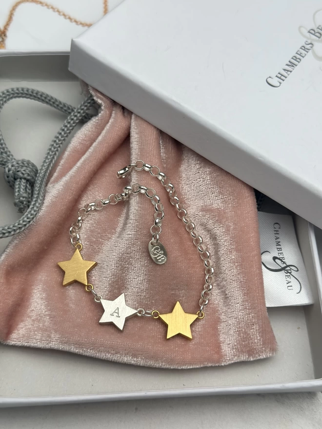 sterling silver belcher chain bracelet with two chunky gold star charms either side of one personalised sterling silver star charm. with gift box and pouch