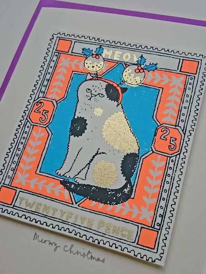 Cat Christmas Card Christmas Puds, a white card with a colourful cat design in the centre, on a purple envelope. 