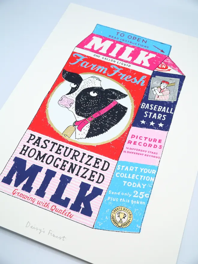 Milk Carton Cow Screenprint Daisy's Finest, a colourful milk carton design on a white screenprint. It sits on a baby blue backdrop. 