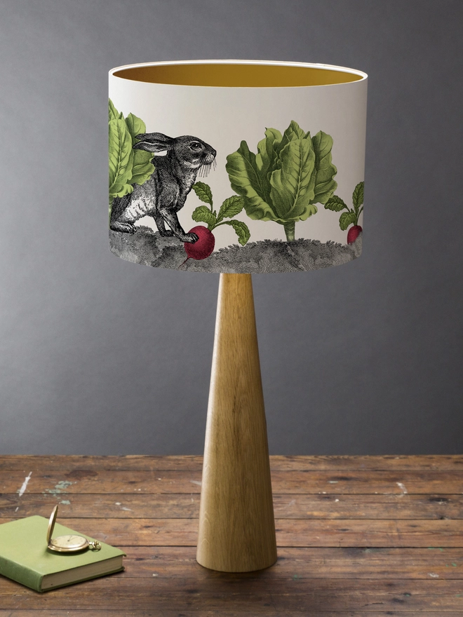 Mischievous rabbit lampshade handmade with vintage animal etchings, hiding among lettuces and radishes in a quirky country-style design. 