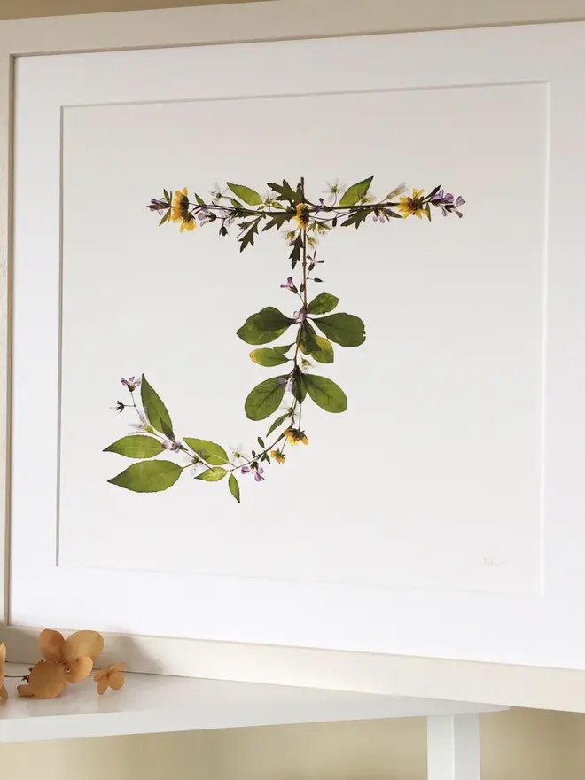 Pressed Wildflower Letter Print, a wildflower alphabet letter print sitting framed. 
