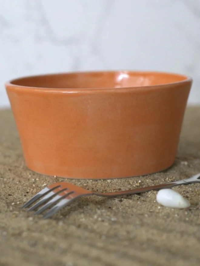 Classic Ceramic Breakfast Bowl, a breakfast bowl sitting on a grey carpet against a plain backdrop. It is accompanied by some cereal and a fork. 