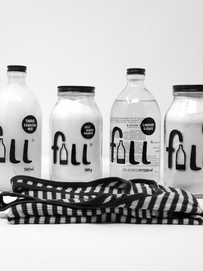 Loads of Laundry. Four jars and bottles of laundry products laid out in front of a towel.