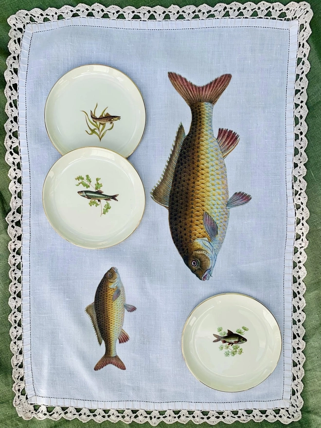 A linen and lace tray cloth that has been given a new lease of life by being printed with images of fish
