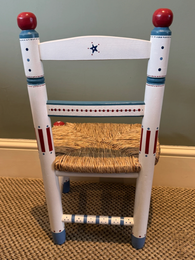 Toby Personalised Children’s Chair. A white chair with intricate blue and red designs.
