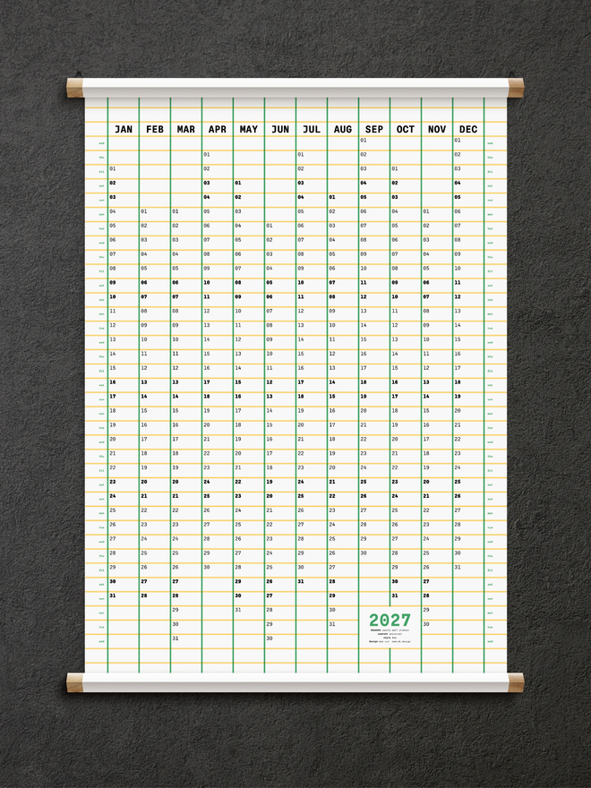 2027 Squared Wall Planner in green, yellow and white on black wall, oak hanger frame.