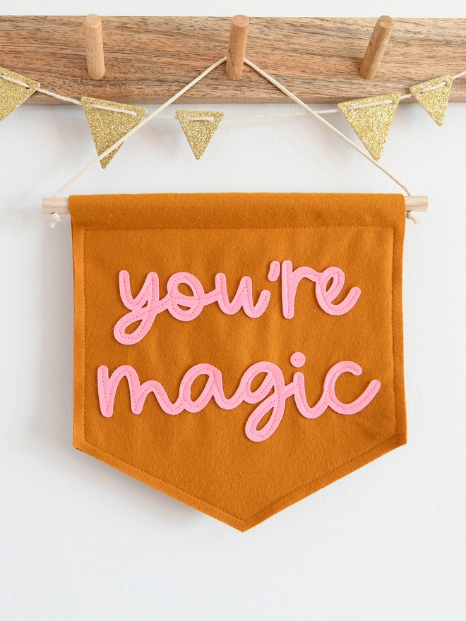 mini felt banner with the words 'you're magic' sewn on.