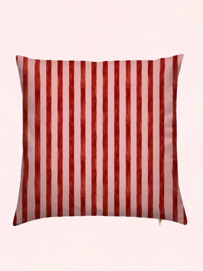 sun stripe cushion. a burgundy and pink striped cushion.