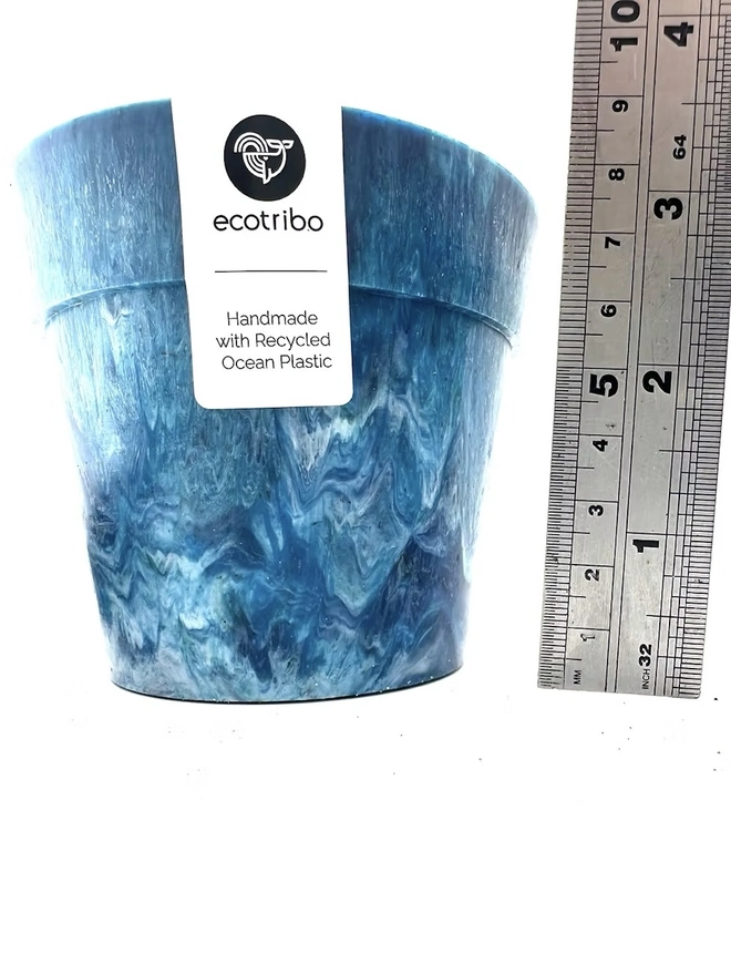 Small Blue Ocean Plastic Plant Pot, a blue recycled pot sitting on a white surface against a plain backdrop. 