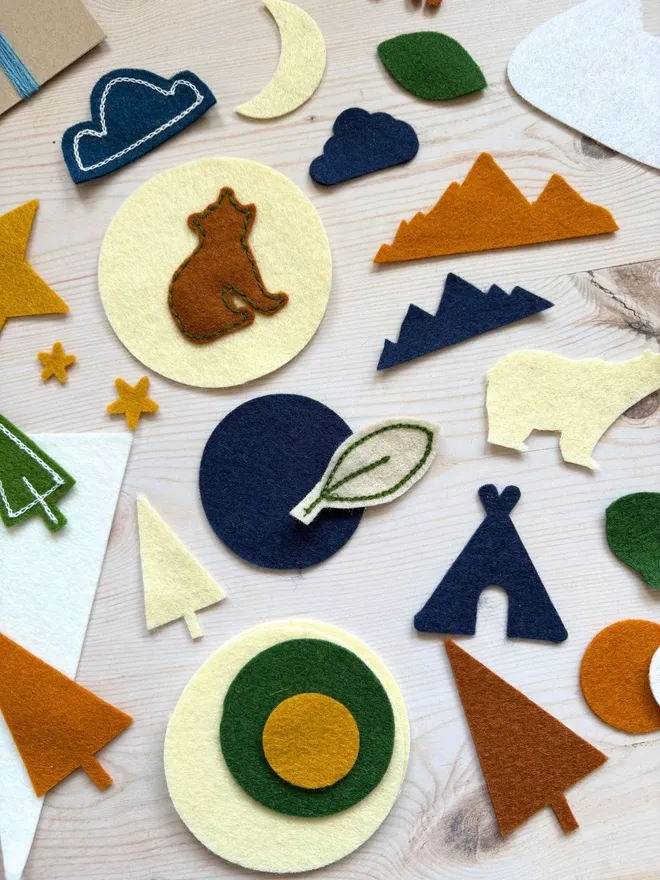 Felt shapes and scraps laid out with an instruction card on a wooden backround