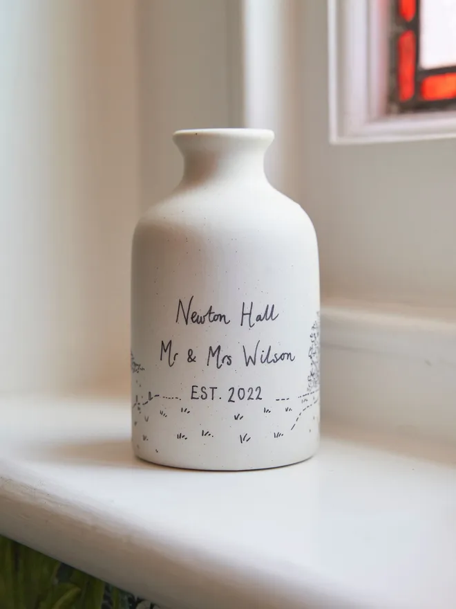 The back of a ceramic vase with black hand written personalisation  