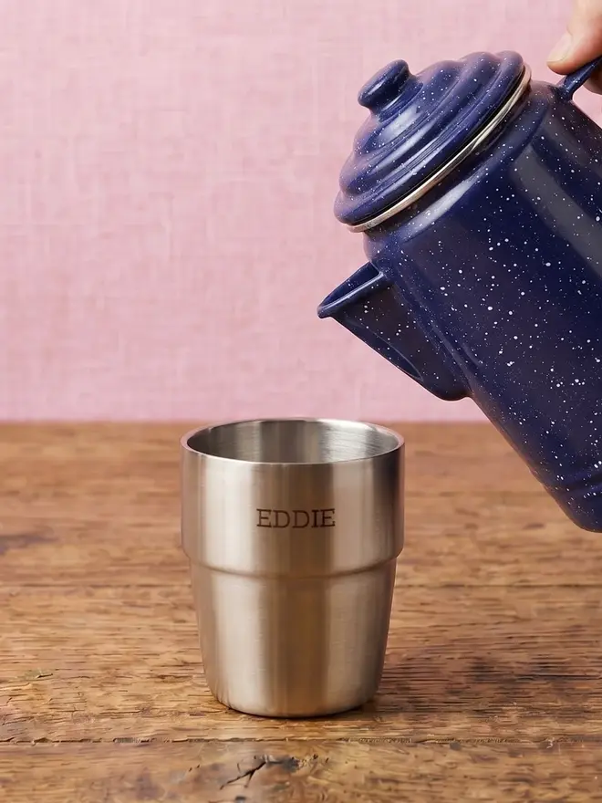 'expedition' stainless steel stacking cups set. a personalised silver steel cup, photographed with a blue ceramic camping kettle. 