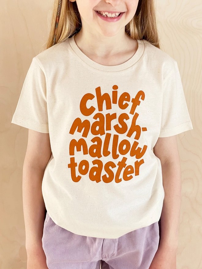 smiling girl wearing a chief marshmallow toaster organic cotton kid's t-shirt 