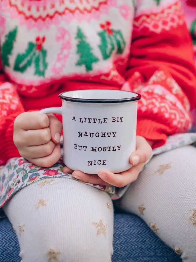 child holding ceramic christmas mug