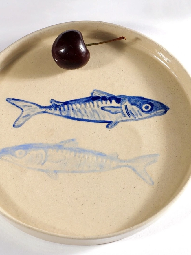 Handmade Ceramic Side Plate With 2 Blue Sardines Design, a white ceramic side plate sitting on a white table surface. 