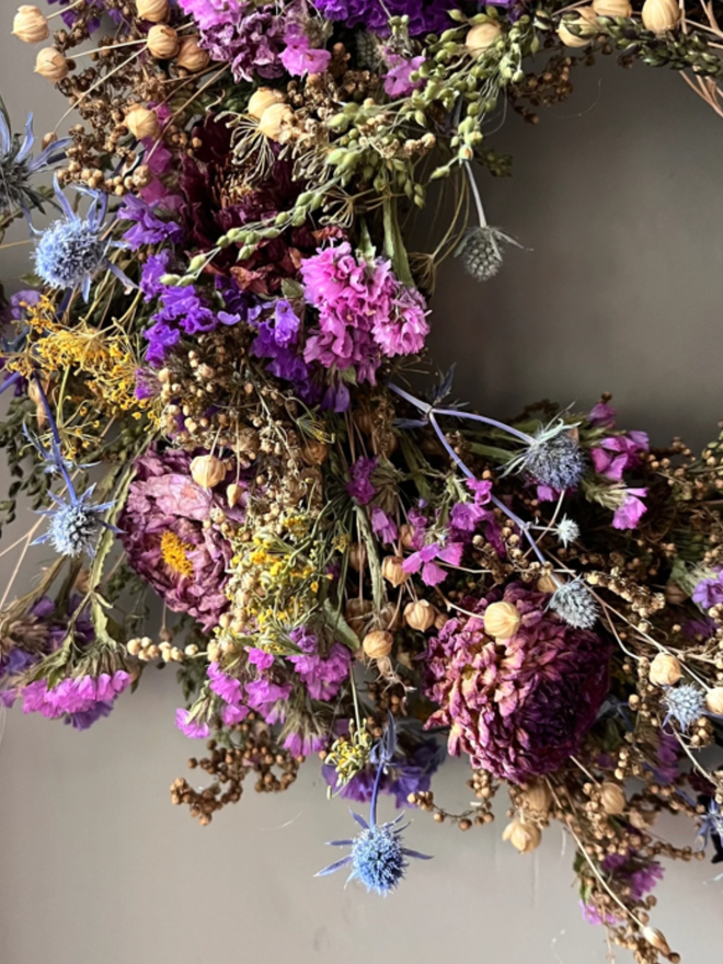 Colourful Autumnal Wreath. An autumnal wreath made of colourful, seasonal flowers, hung on a wall.