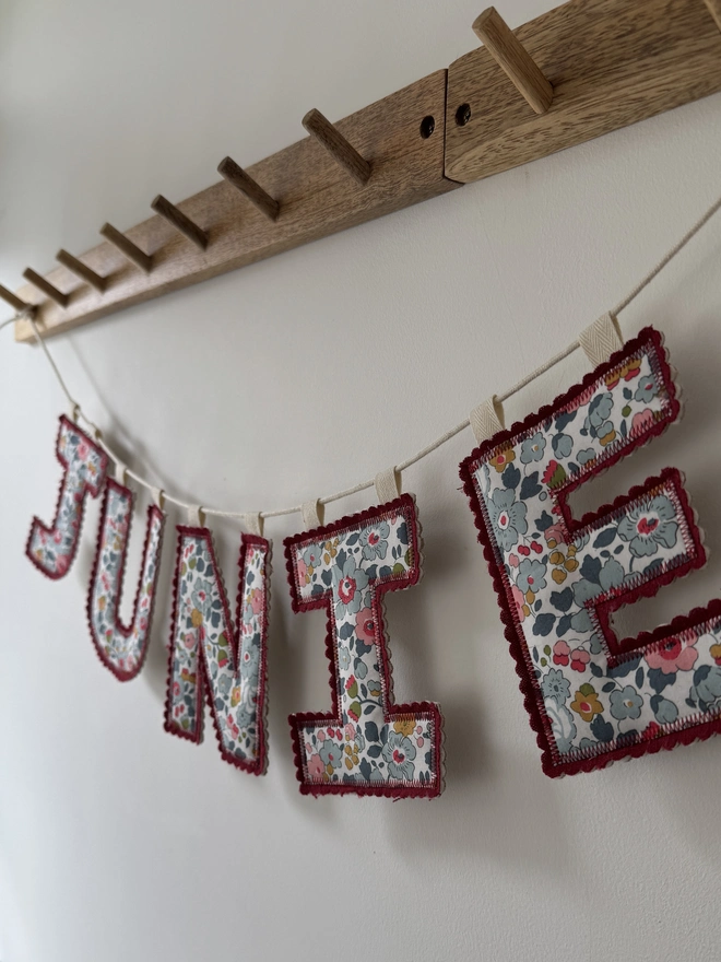 Fabric Letter Garland.  A letter garland in red florals spelling JUNIE