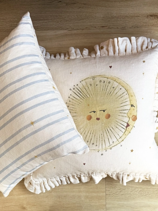 'Astral Weeks' Linen Ruffled Cushion Cover, a white and yellow cushion with a sun motif. 