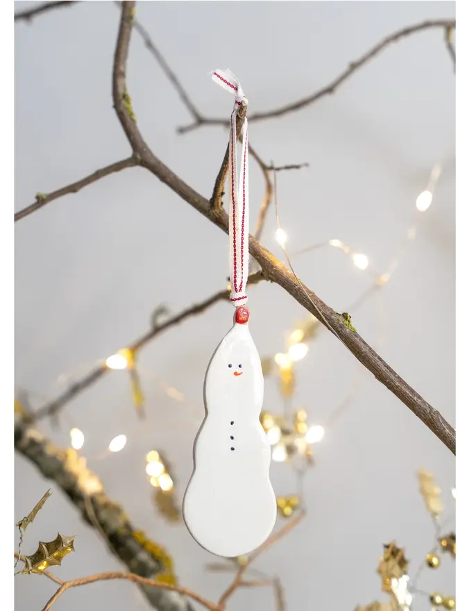 Ceramic snowman hanging decoration with red bobble and cotton ribbon