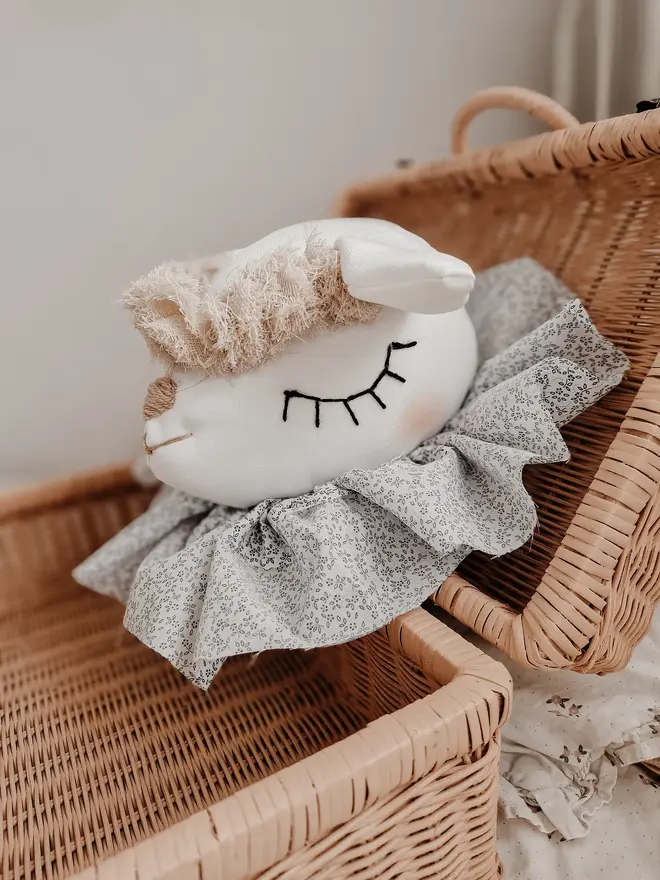 Sheep Head Wall Mount, a hanging sheep head decoration sitting against a plain wall in child's bedroom. 