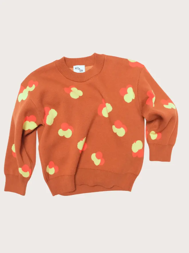 Front flat lay of the Studio Koter Fynn jumper, a chestnut jacquard knit with yellow and orange floral motif and ribbed crew neck.