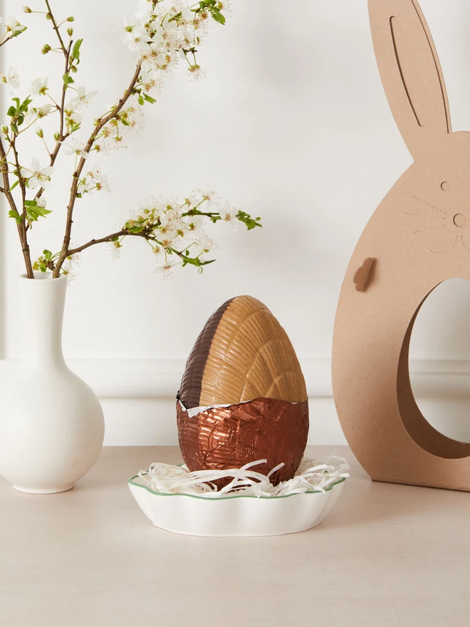 affogato coffee chocolate easter egg. a coffee chocolate easter egg photographed partially unwrapped from bronze foil.