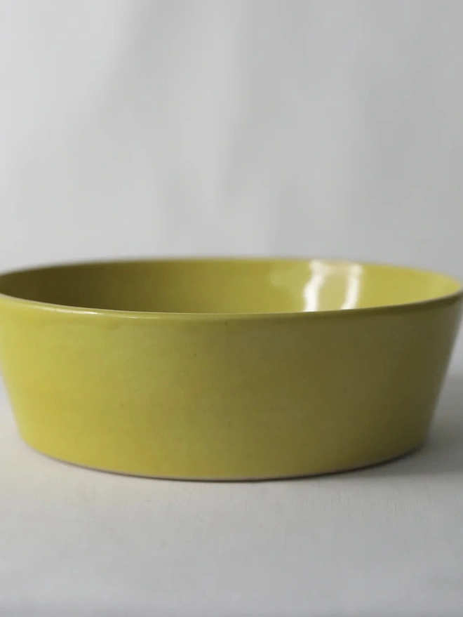 Classic Pasta Bowl, a colourful ceramic bowl sitting on a plain surface against a grey backdrop. 