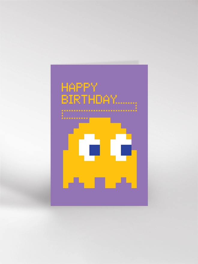 A Happy Birthday card featuring an illustration of an arcade game character